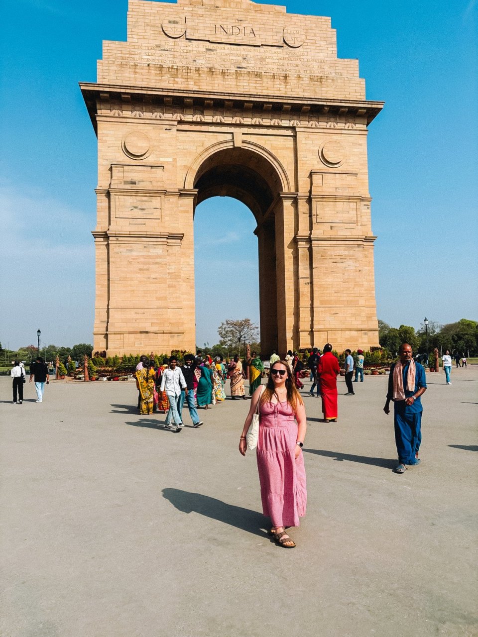 A young female traveller posing in front of the India gate in Delhi whilst on tour with TruTravels