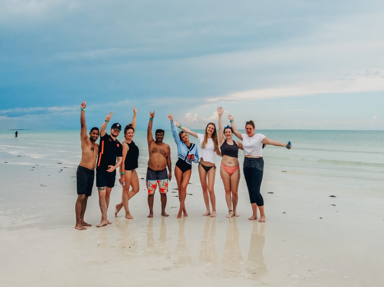 A group of people posing on the beach.